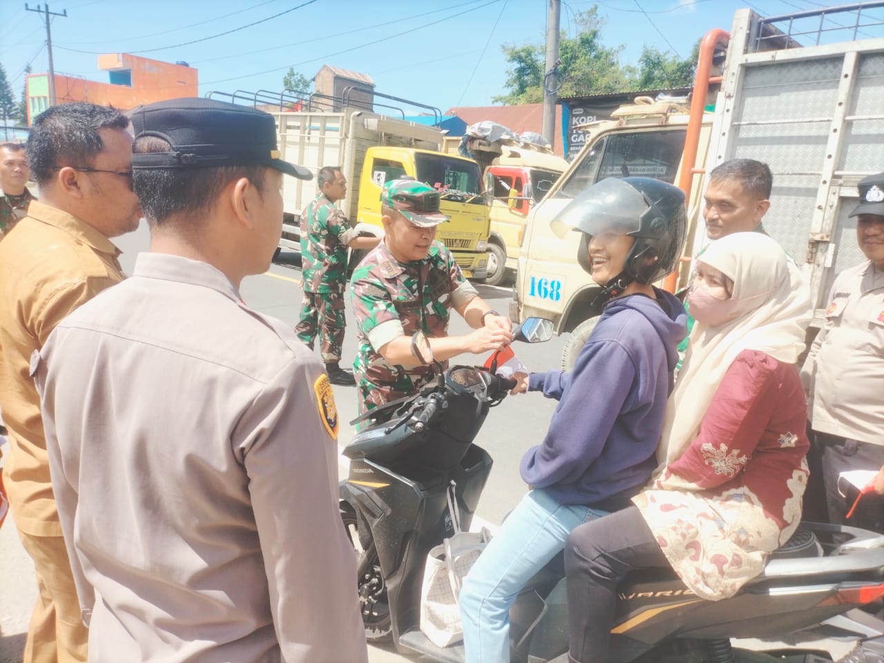 Bhabinkamtibmas Polsek Tigapanah Bagikan Bendera Merah Putih, Ajak Warga Jaga Keamanan Desa